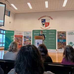Padraig healy from Vision Sports speaks at a podium on a stage infront of posters for VIP Hub, Laois Sports Partnership, Vision Sports Ireland and IWA